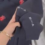 Coeur rouge avec la première lettre de vos noms et l'infini brodé sur les manches