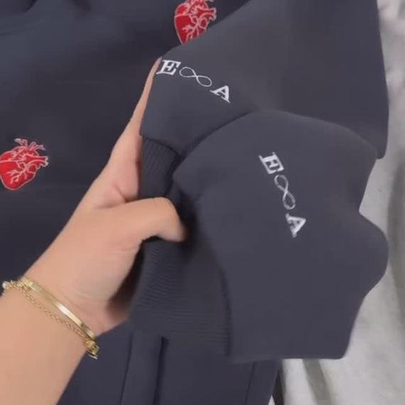 Coeur rouge avec la première lettre de vos noms et l'infini brodé sur les manches